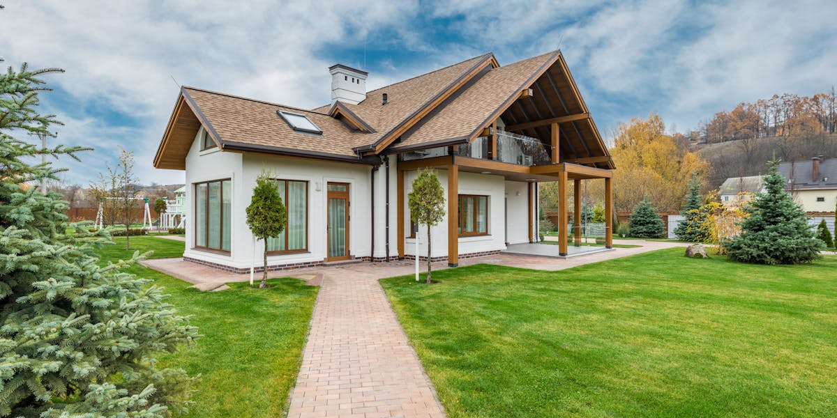 Home exterior with landscaping and brick pathway — water damage from improper grading is the most expensive and most preventable problem