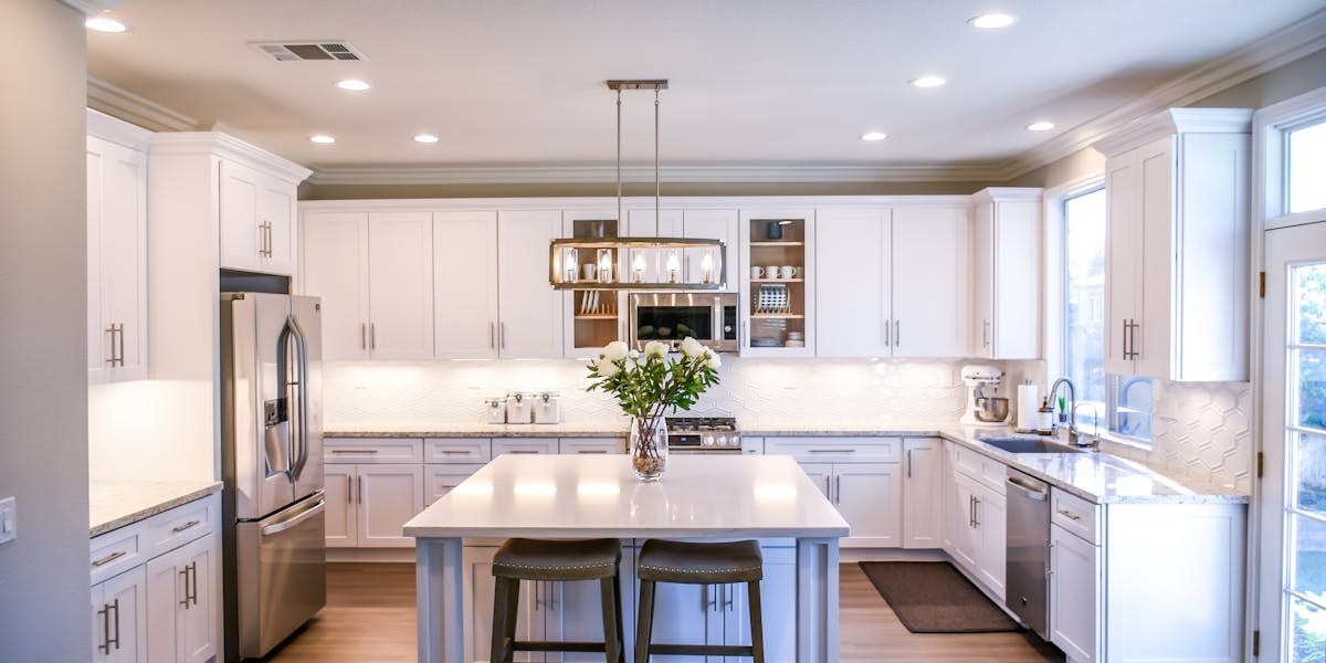 Beautiful white kitchen with island — renovated homes need inspections more than any other type of property