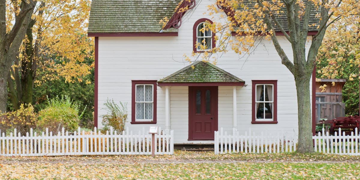 Charming home with white picket fence in autumn representing seasonal market changes