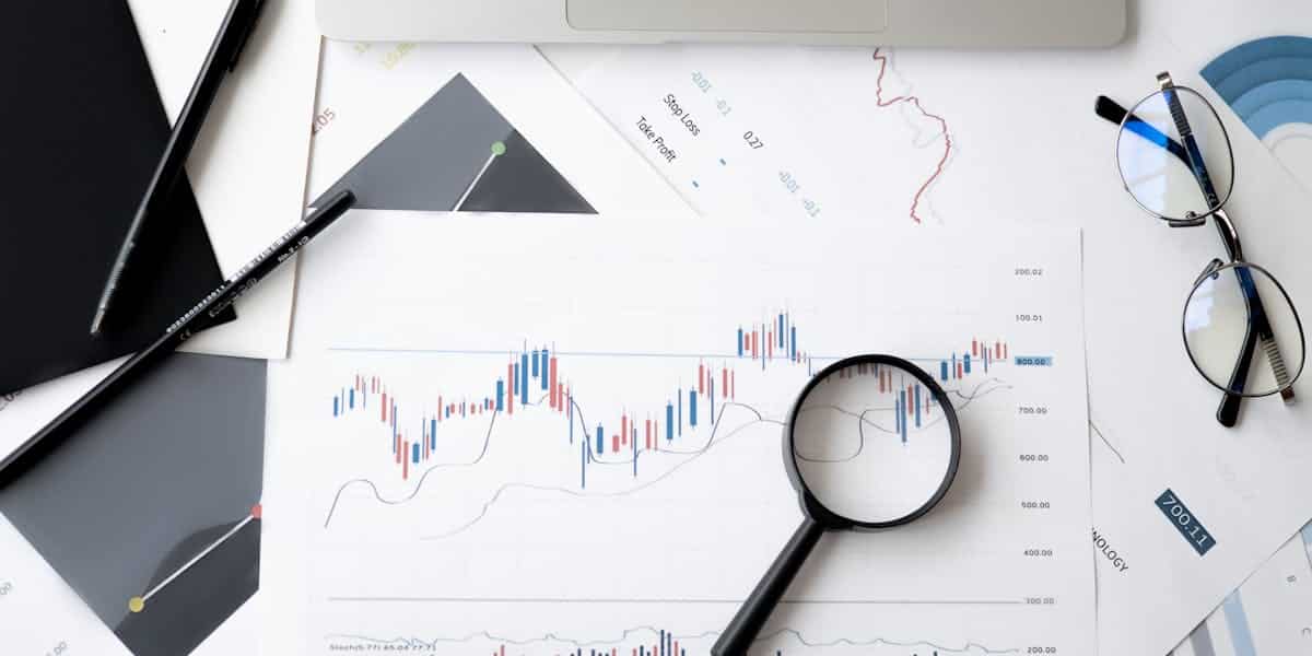 Market analysis charts and data with magnifying glass