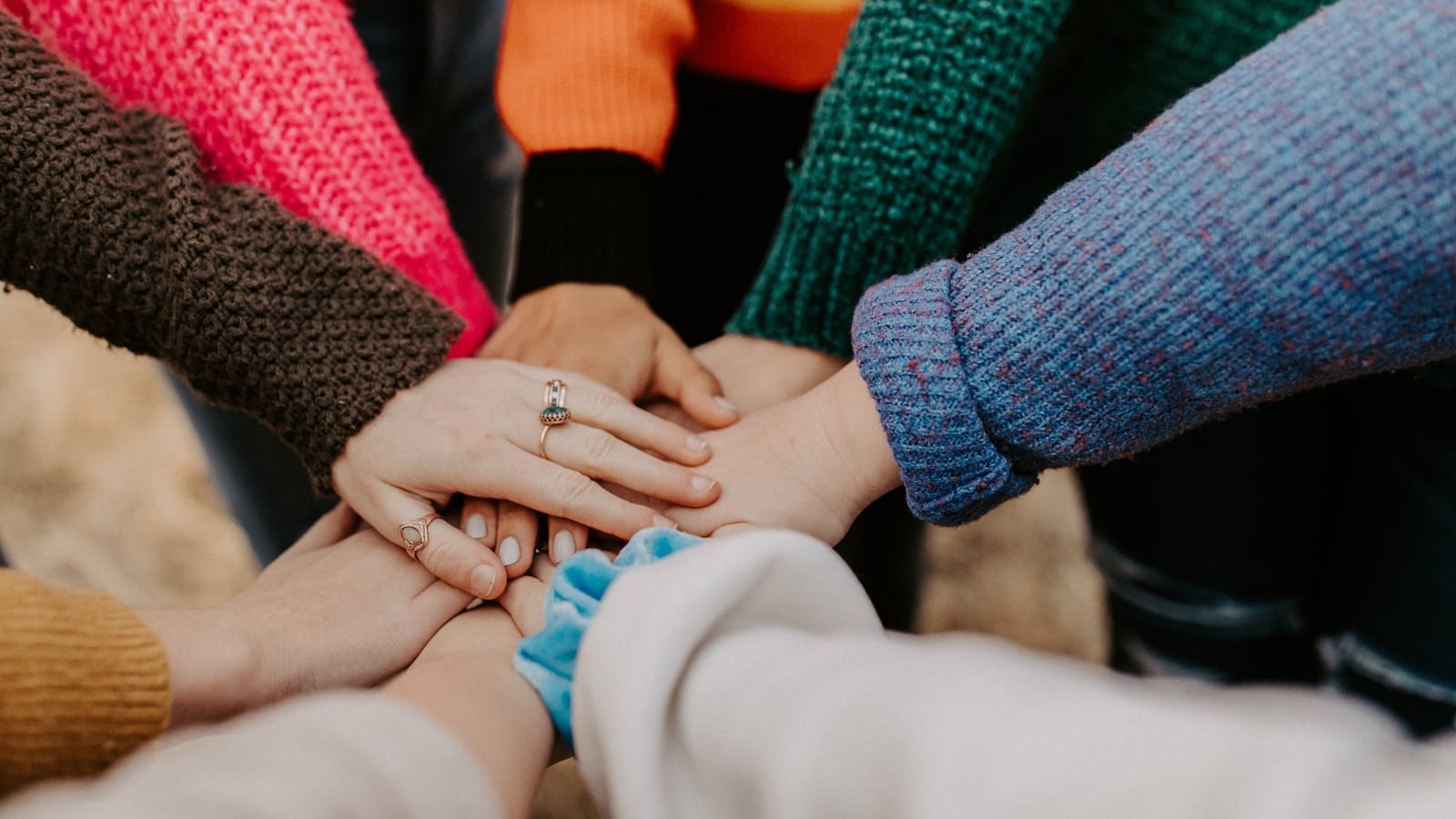 Hands stacked together in a circle showing unity and community support