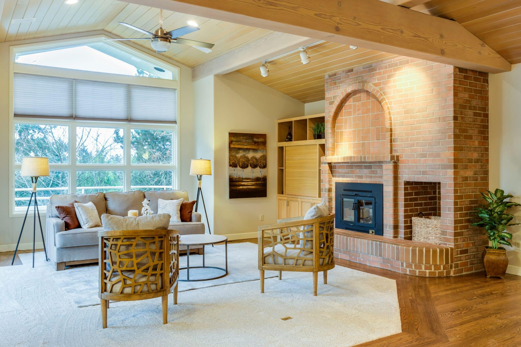 Living room with brick fireplace, ceiling fan, and vaulted ceiling — check these systems regularly