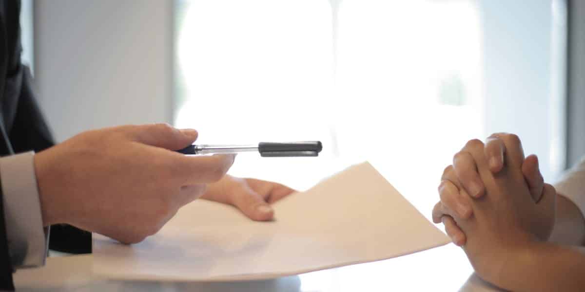 Person signing mortgage pre-approval documents at a desk